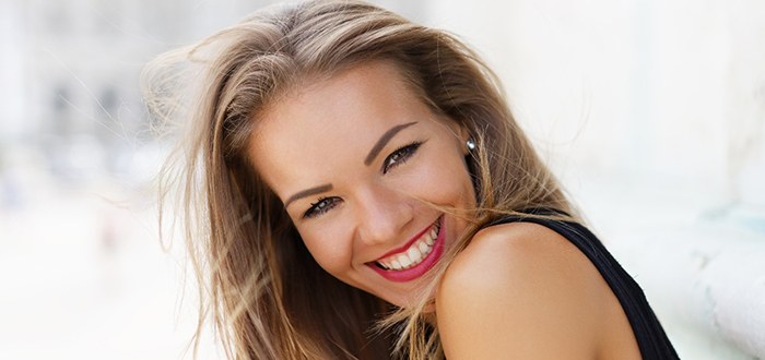 Woman smiling brightly after cosmetic dentistry in Schaumburg
