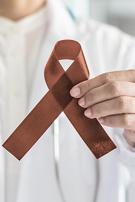 a dentist holding up an oral cancer awareness ribbon