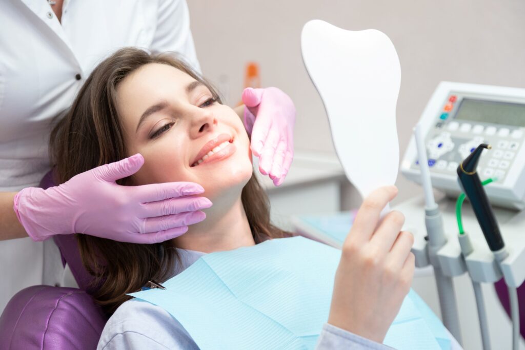 Dentist framing patient's smile with purple gloved hands
